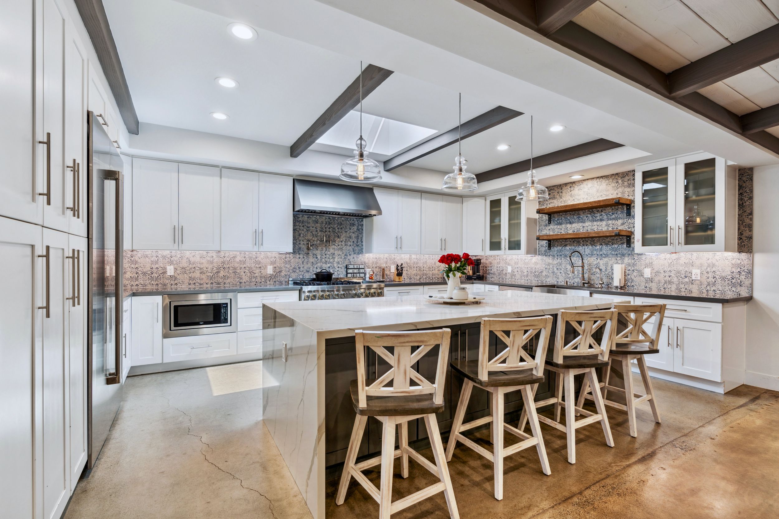 Bright white kitchen with island seating in the Valley Home, a custom home built by a UBuildIt San Diego owner-builder client in Carlsbad, CA